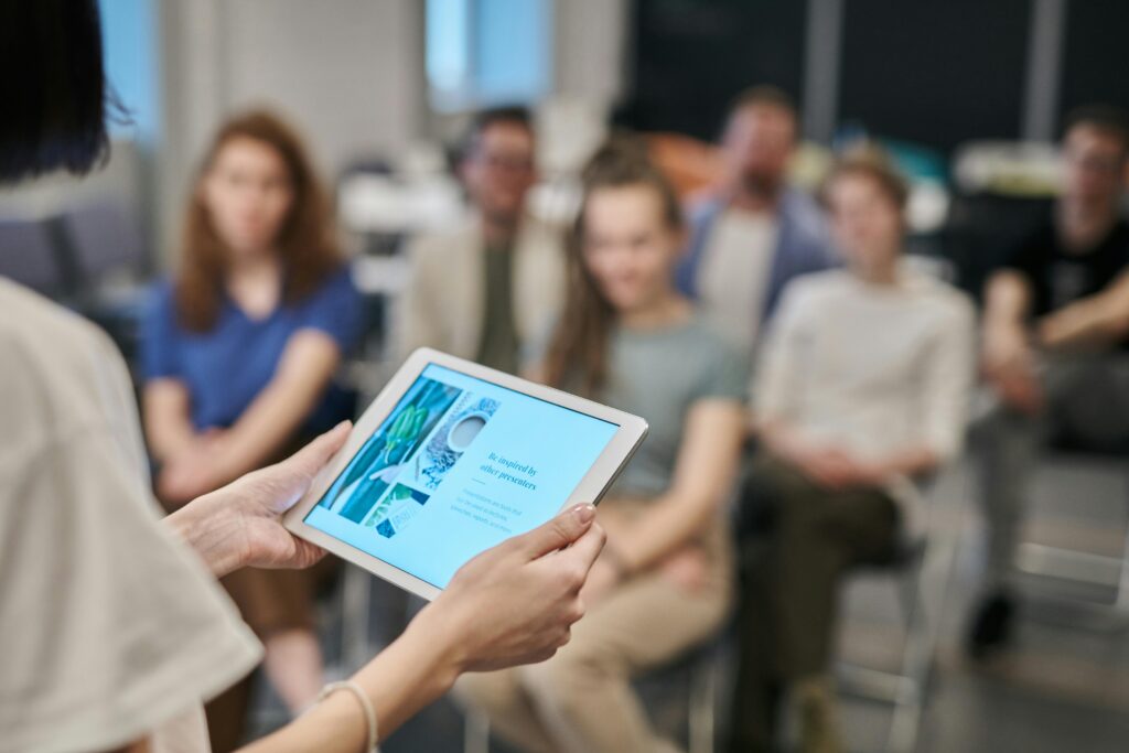 pexels-photo-3183169-3183169 Business seminar with participants focused on a tablet presentation in an office setting.